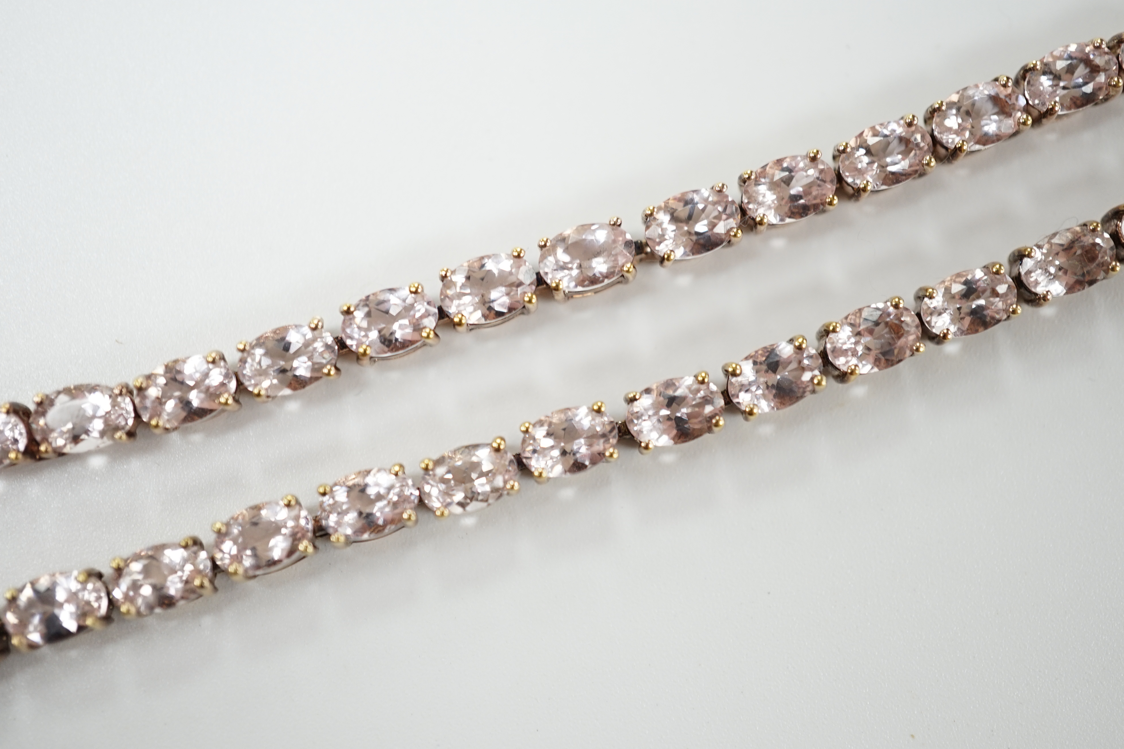 A modern 925 gilt metal and oval cut morganite set line necklace, 46cm.